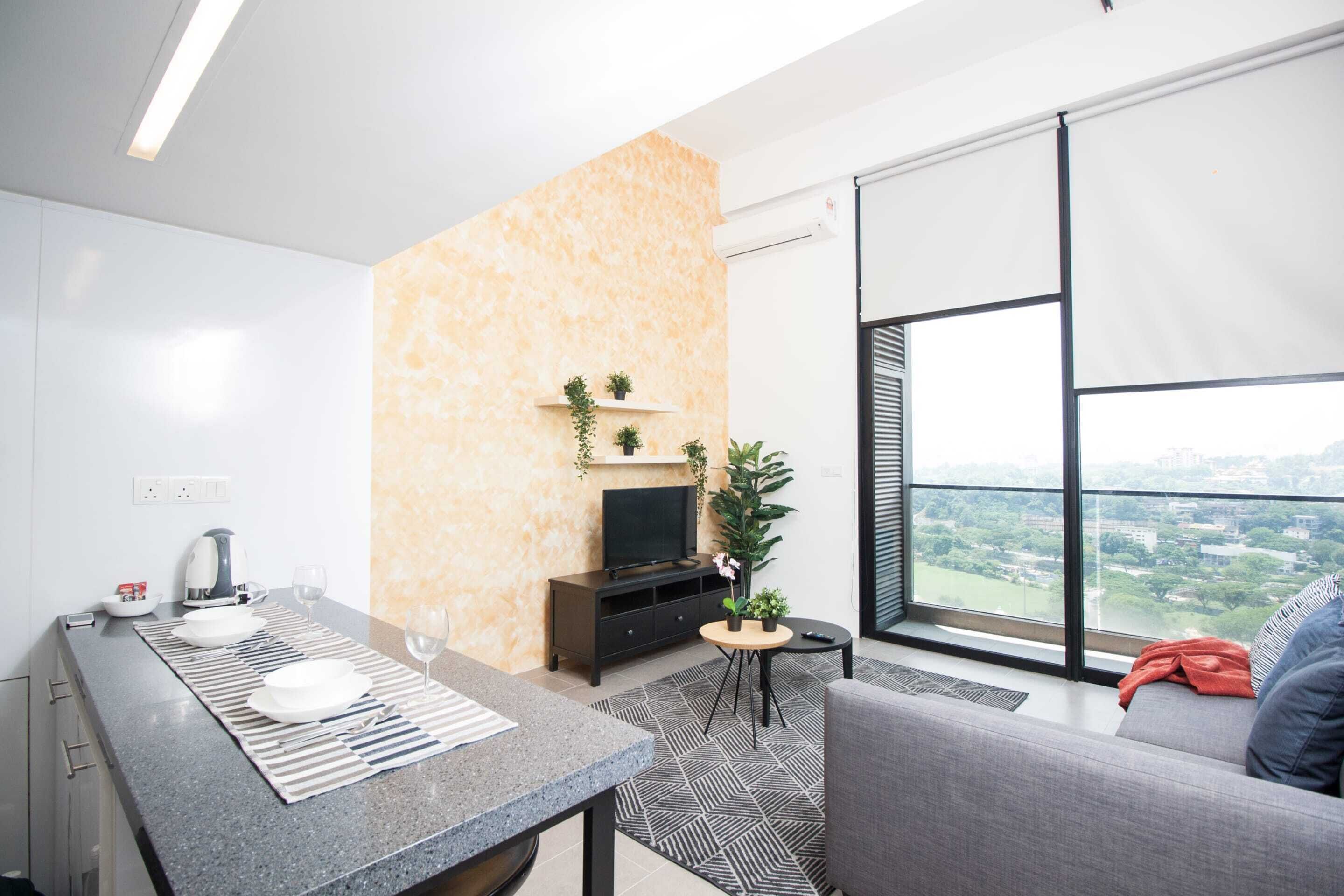 A modern living room with a sofa, a dining area with a table and chairs, a TV on a stand, and a large window offering a city view.