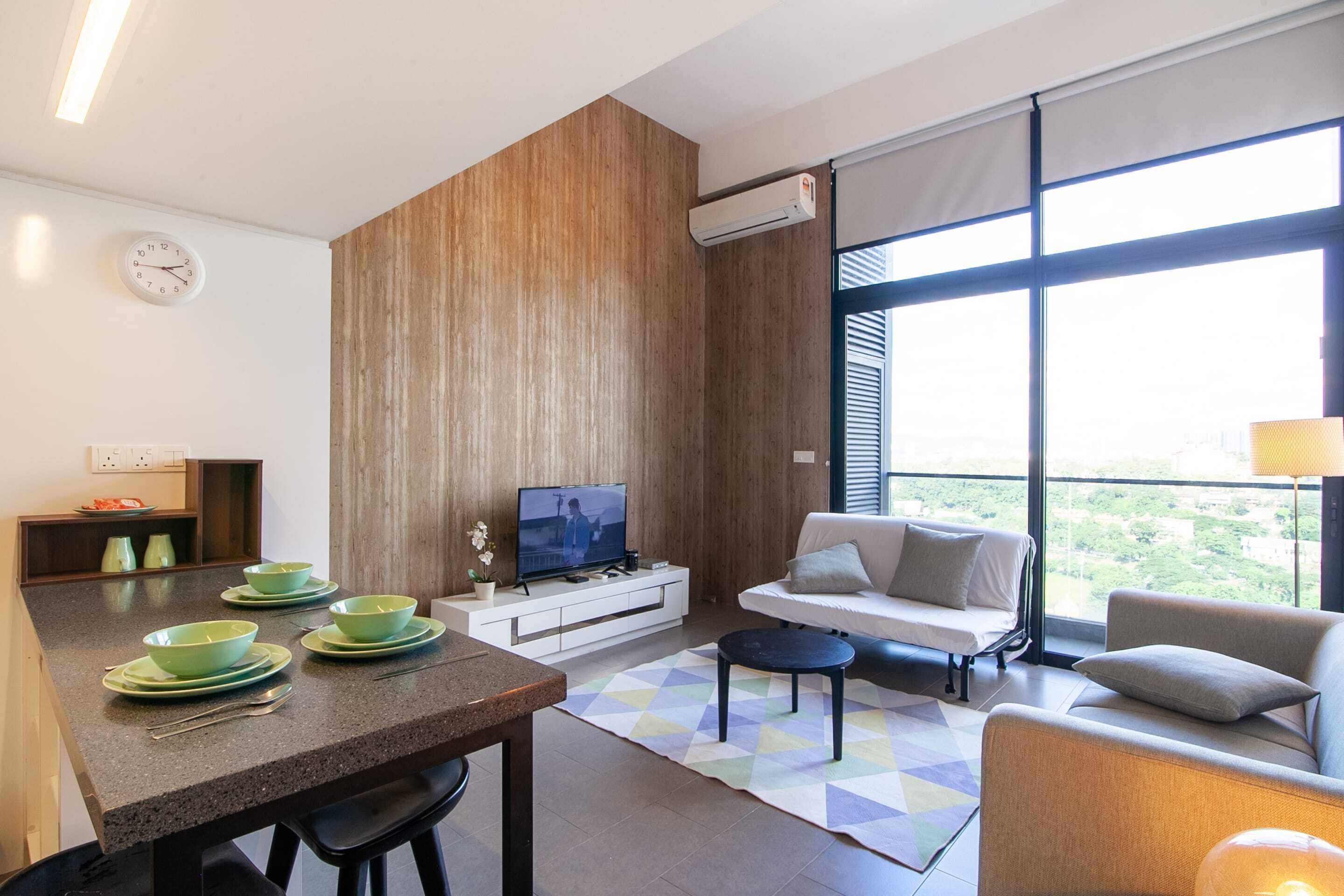 Una sala de estar moderna con comedor, un sofá, televisor y un amplio ventanal con vistas.