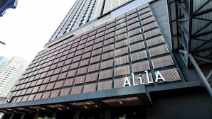 Un bâtiment moderne à la façade structurée en forme de grille, sur lequel le nom « AIA » est clairement affiché.