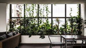 Une pièce avec une grande fenêtre, un canapé, une table et des chaises.