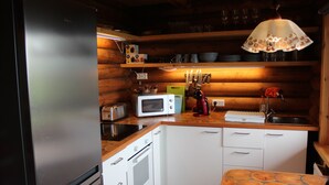A compact kitchen with a refrigerator, microwave, toaster, and a sink.