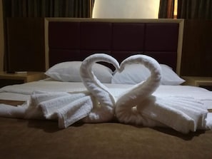 A hotel room with a bed, pillows, and a decorative towel arrangement in the shape of swans. - Yacht Hotel Aqaba (Aqaba)