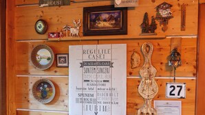 A wooden interior with a 'Welcome Coffee House' sign, a framed picture, a cuckoo clock, and a chair. - Chalet Milenium Residence Bran (Bran)