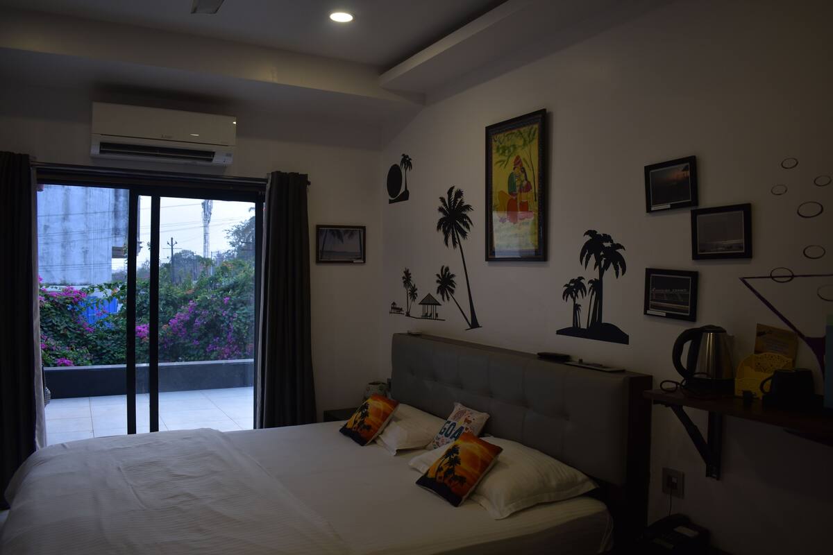 Ein Hotelzimmer mit Bett, Blick ins Freie und verschiedenen Wanddekorationen.