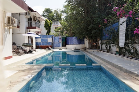 Una piscina al aire libre, sillones reclinables de piscina