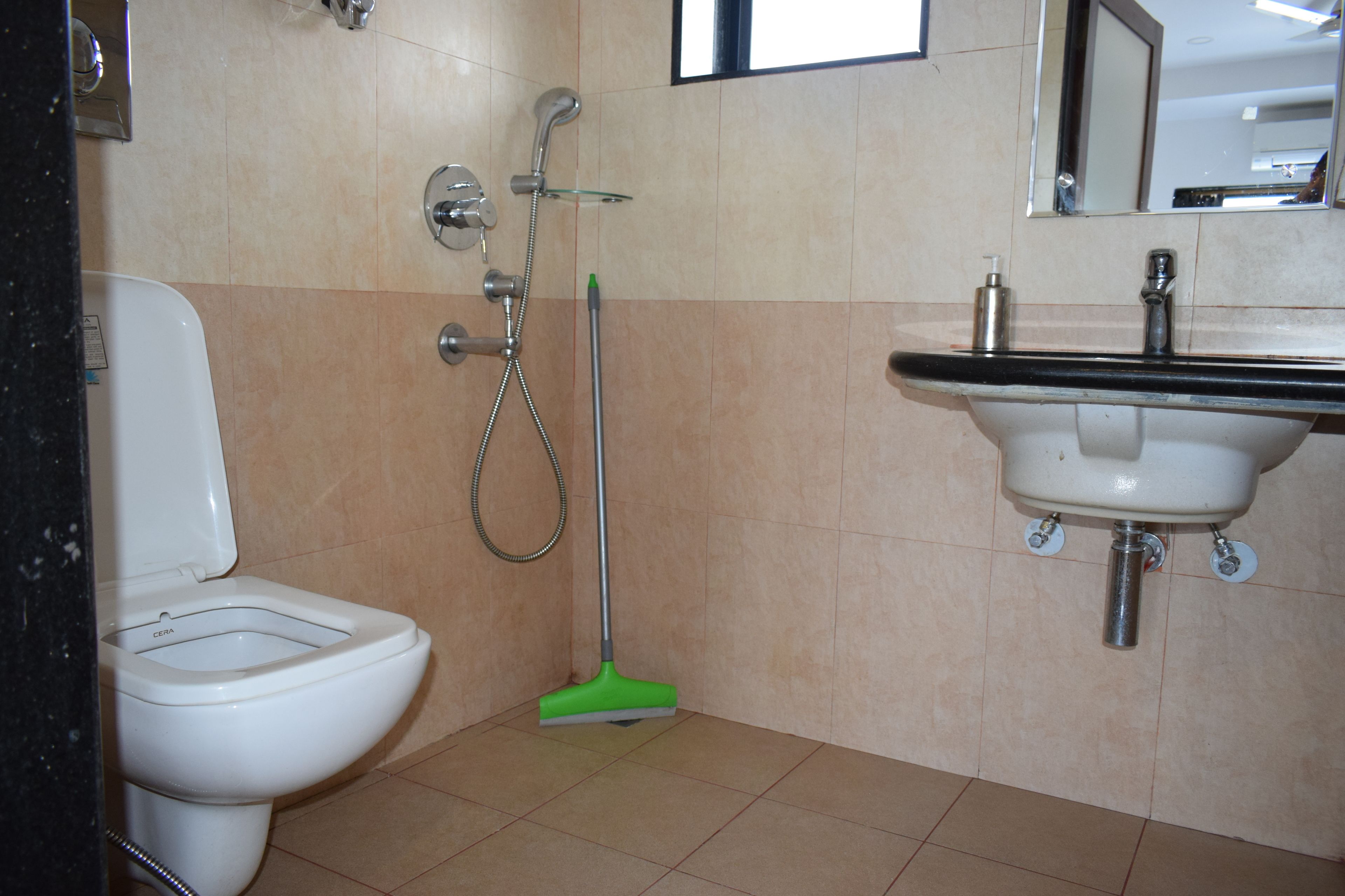 A bathroom with a toilet, a shower, and a sink.