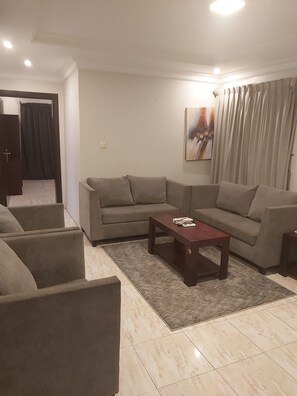 Un salon avec un canapé d’angle, une table basse et un tapis.
