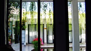 Une pièce donnant sur un jardin, avec une fenêtre équipée de stores verticaux.