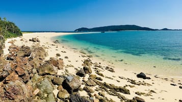 Una playa cerca, arena blanca, camas de playa, toallas de playa