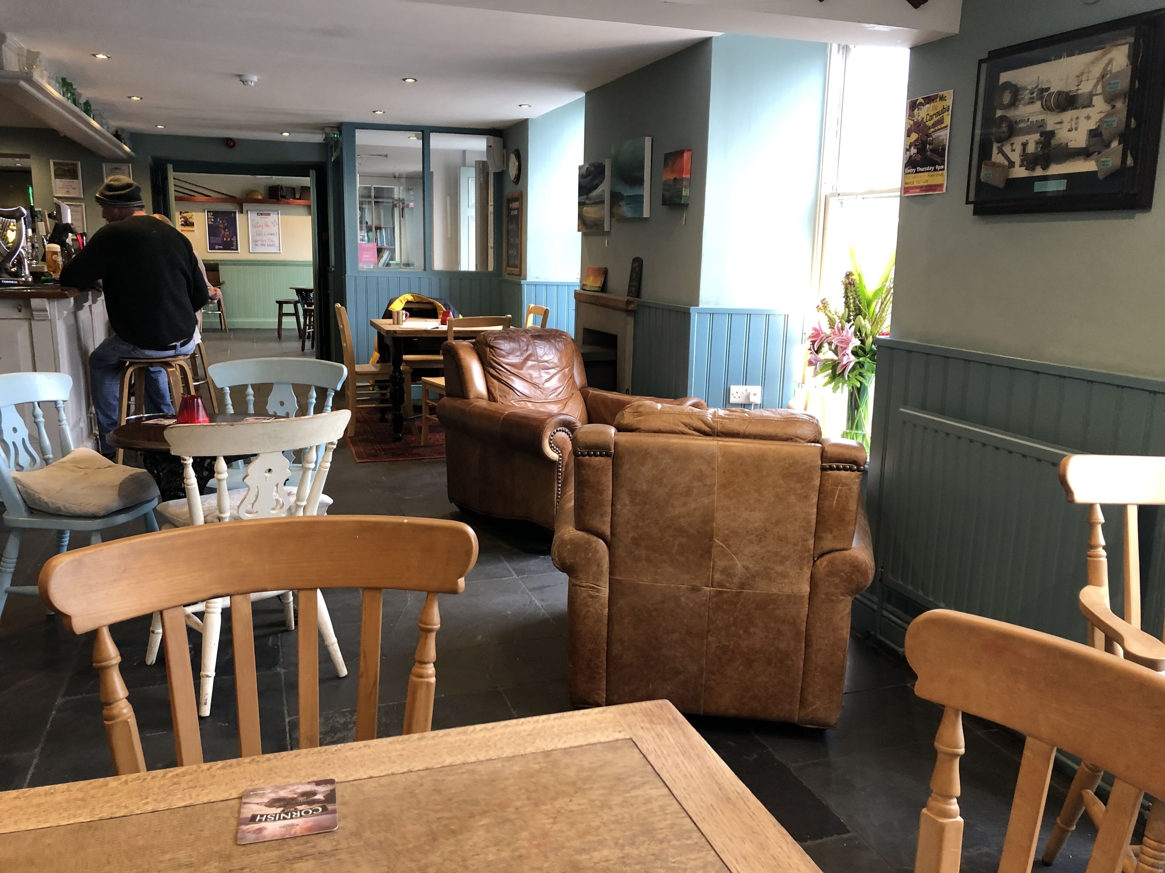 A cozy interior with wooden furniture, a leather sofa, and a bar area.