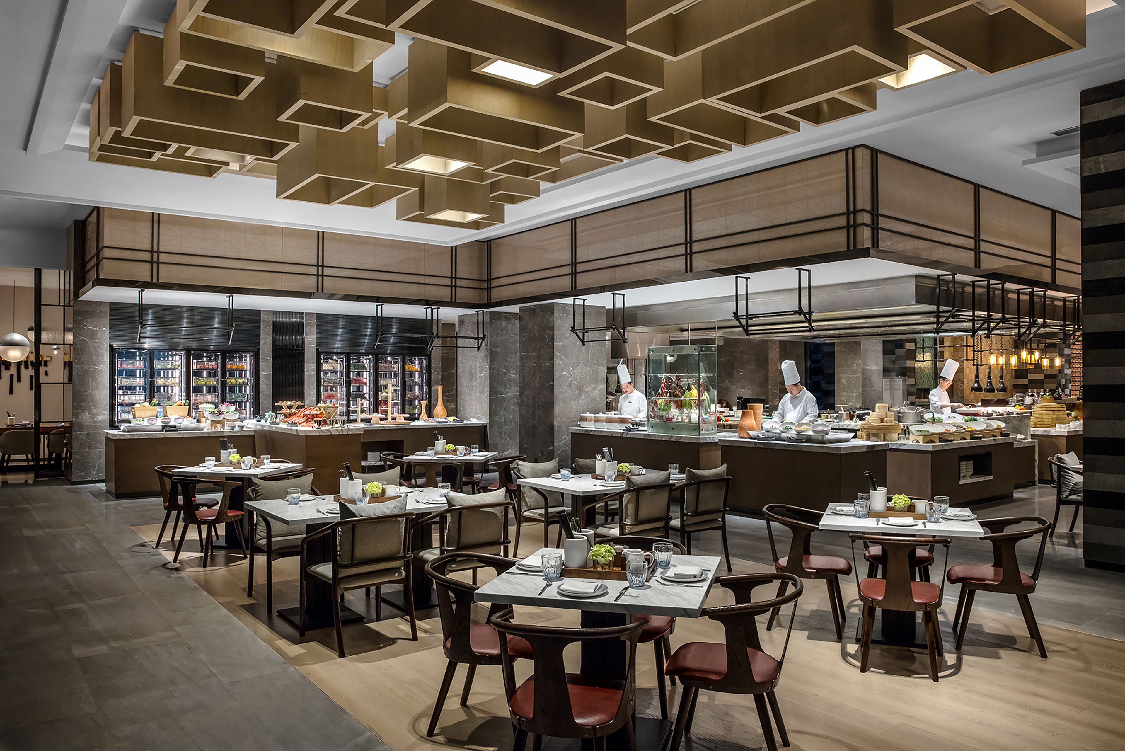A modern restaurant with multiple dining areas, a central kitchen, and a bar.