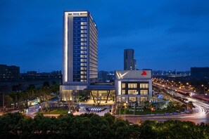 A modern hotel with a tall building and a shorter structure with a checkmark logo.