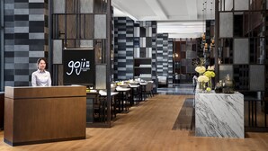 A modern hotel lobby with a reception desk, seating area, and decorative elements.