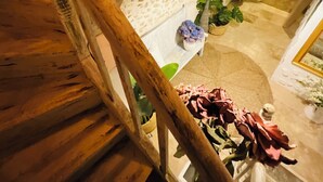 A wooden staircase with a stone wall and a potted plant. - Labyrinthe (Mirepoix)