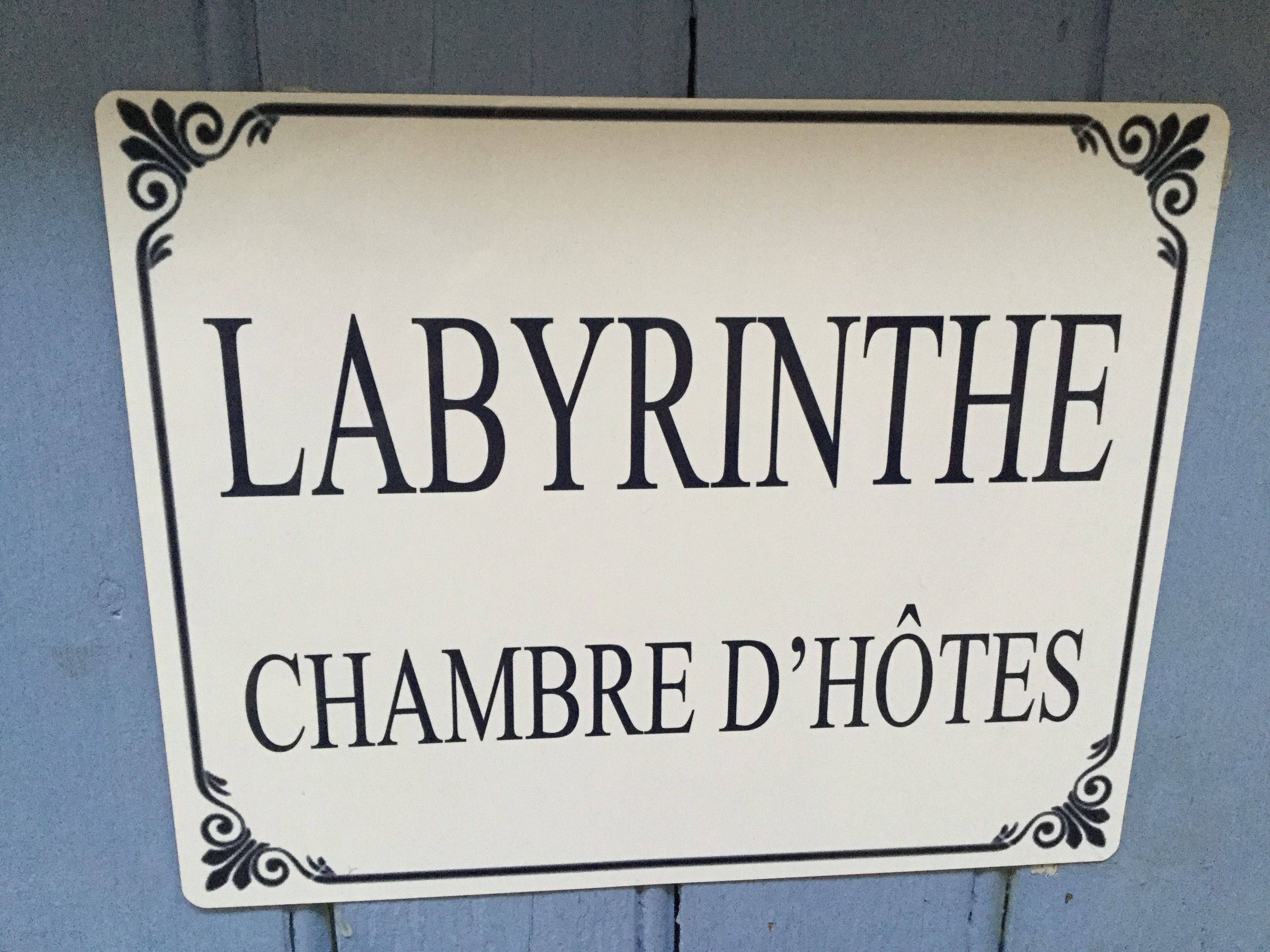 A sign with the text "LABYRINTHE" and "CHAMBRE D'HOTES".