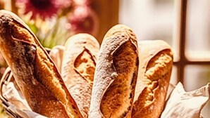 A wicker basket filled with baguettes on a table. - Labyrinthe (Mirepoix)