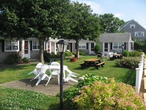 Enjoy outdoor dining or relaxation in the seating area surrounded by a well-maintained lawn.