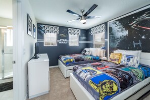 A bedroom with Star Wars themed bedding, a ceiling fan, and a large mirror reflecting the room. - Westside Triumph | Corner Lot With No Rear Neighbors with Loft & Game Room (Kissimmee)