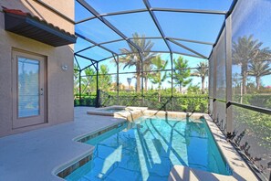 A swimming pool with a covered area, a door, and palm trees in the background.