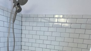 A bathroom with a white bathtub, a showerhead, and a wall-mounted faucet. - Spacious 2nd floor Condo with Two Large Balconies! (Ocean City)