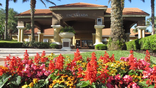 A hotel entrance with a sign reading "ENCANTADA" and a large planter in front. - Amazing Lake View : 4 Bed End Townhouse : Super Fast WiFi : Private Pool (Kissimmee)