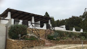 Un edificio con facciata in pietra, scalini in legno e tetto in metallo.