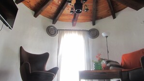 Een kamer met een houten plafond, een stoel, een tafel en een bank.