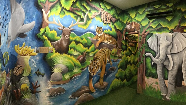 Un mural con varios animales y un río.