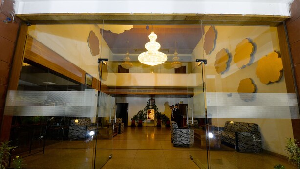 A lobby with a chandelier, potted plants, and a seating area. - Shivam Resorts (Jaipur)