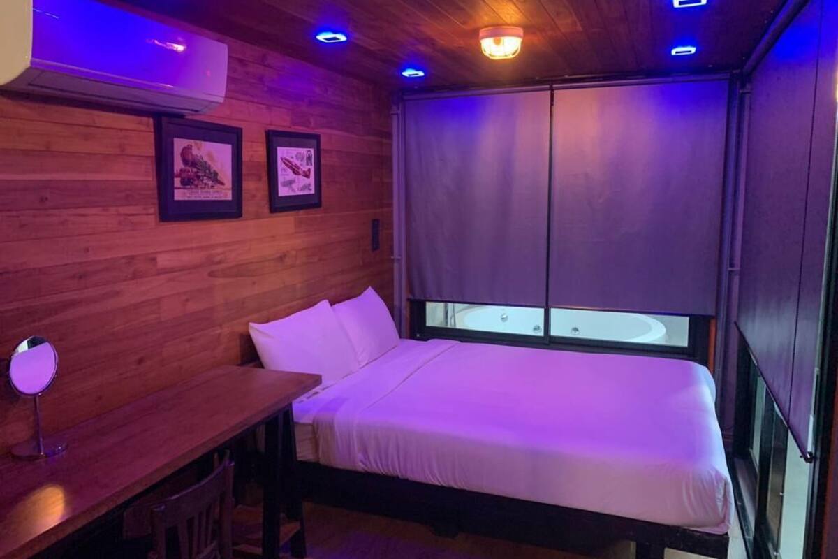Une chambre avec un lit, un bureau et un miroir.
