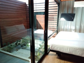 A bedroom with a bed, a window, and a view of a garden. - Kong Resort Vangvieng (Vang Vieng)
