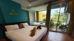 A hotel room with a bed, a small table, and a view of the outdoors. - Porterhouse Beach Hotel (Patong)