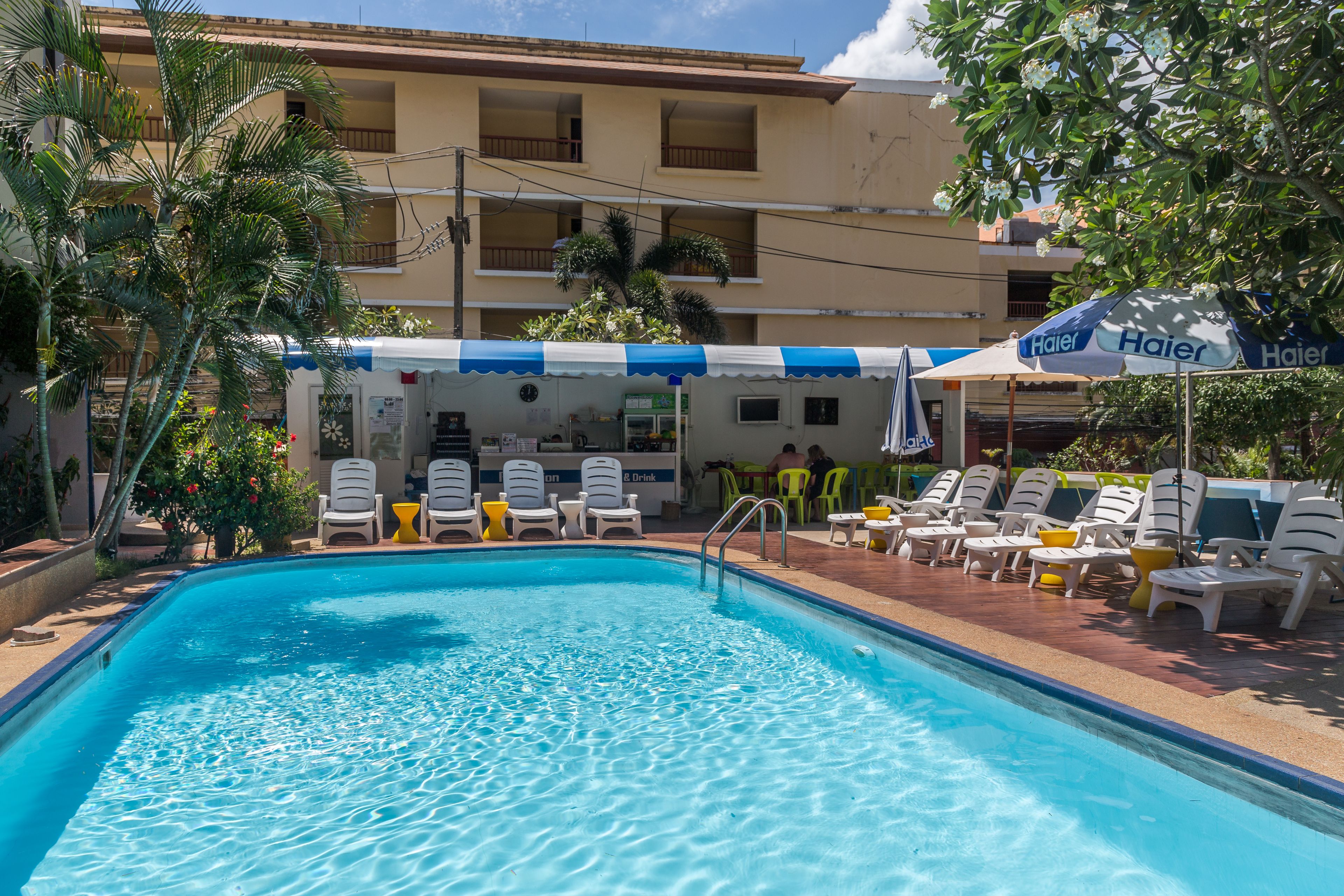 A swimming pool with lounge chairs and a shaded area with umbrellas.