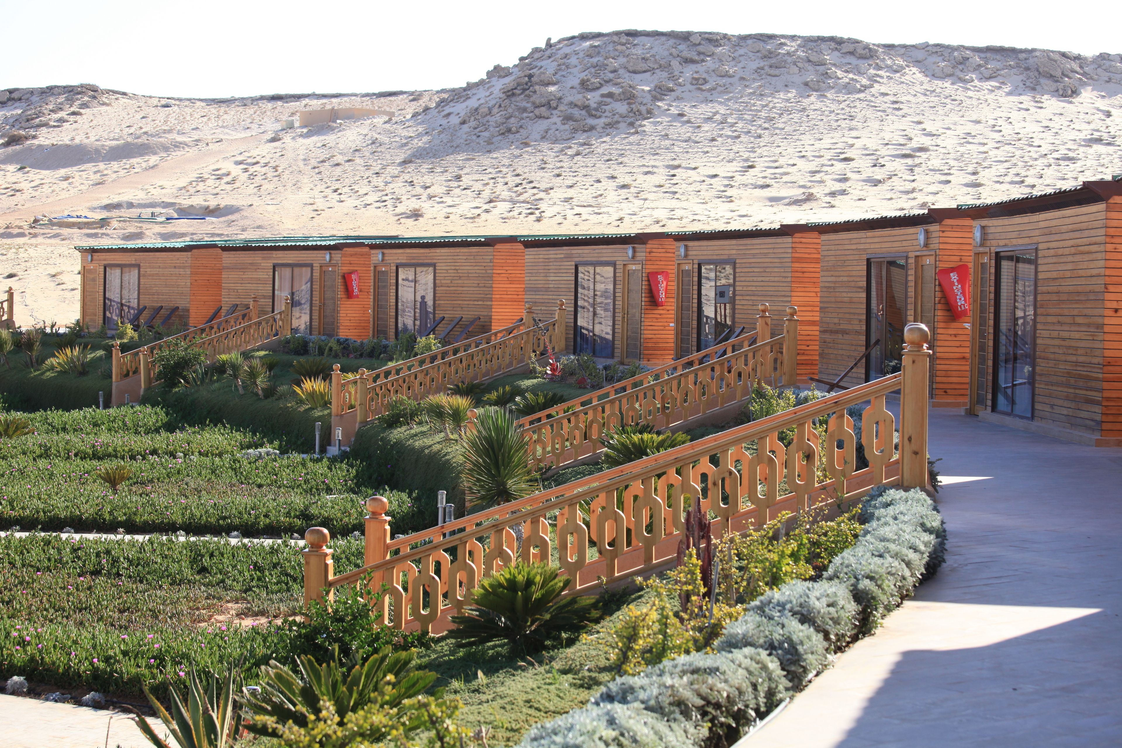A hotel with a wooden facade, a central staircase, and a landscaped garden.