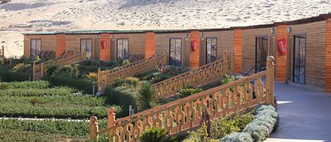 A hotel with a wooden facade, a central staircase, and a landscaped garden.