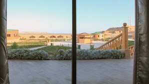 Un balcón con vistas a un paisaje desértico, que incluye edificios y una colina distante.