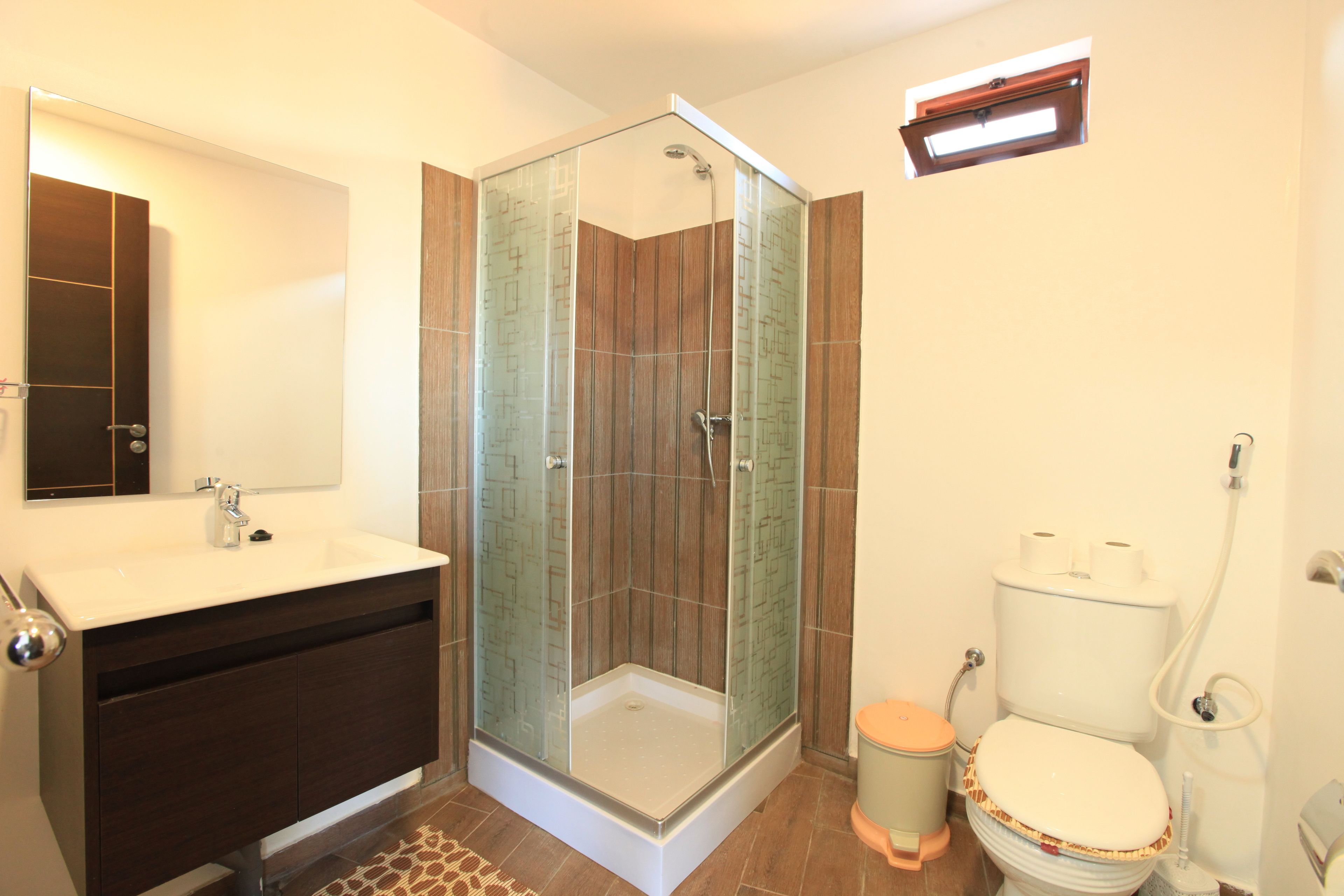 Un bagno moderno con doccia vetrata, lavandino bianco e water.