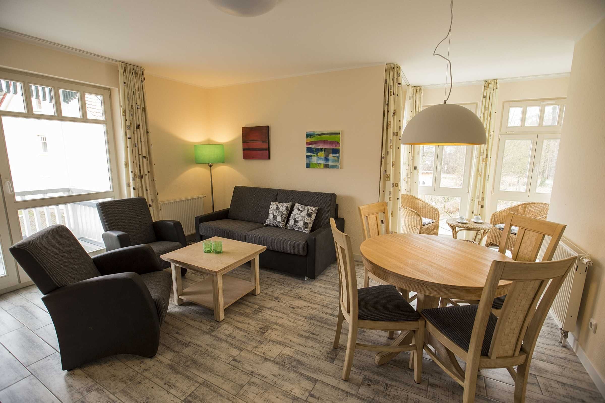 Ein Wohnzimmer mit einer Couch, Stühlen, einem Tisch und einem Essbereich mit Stühlen.