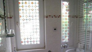 A bathroom with two sinks, a toilet, and a shower. - Holiday house in the old town (Barth)