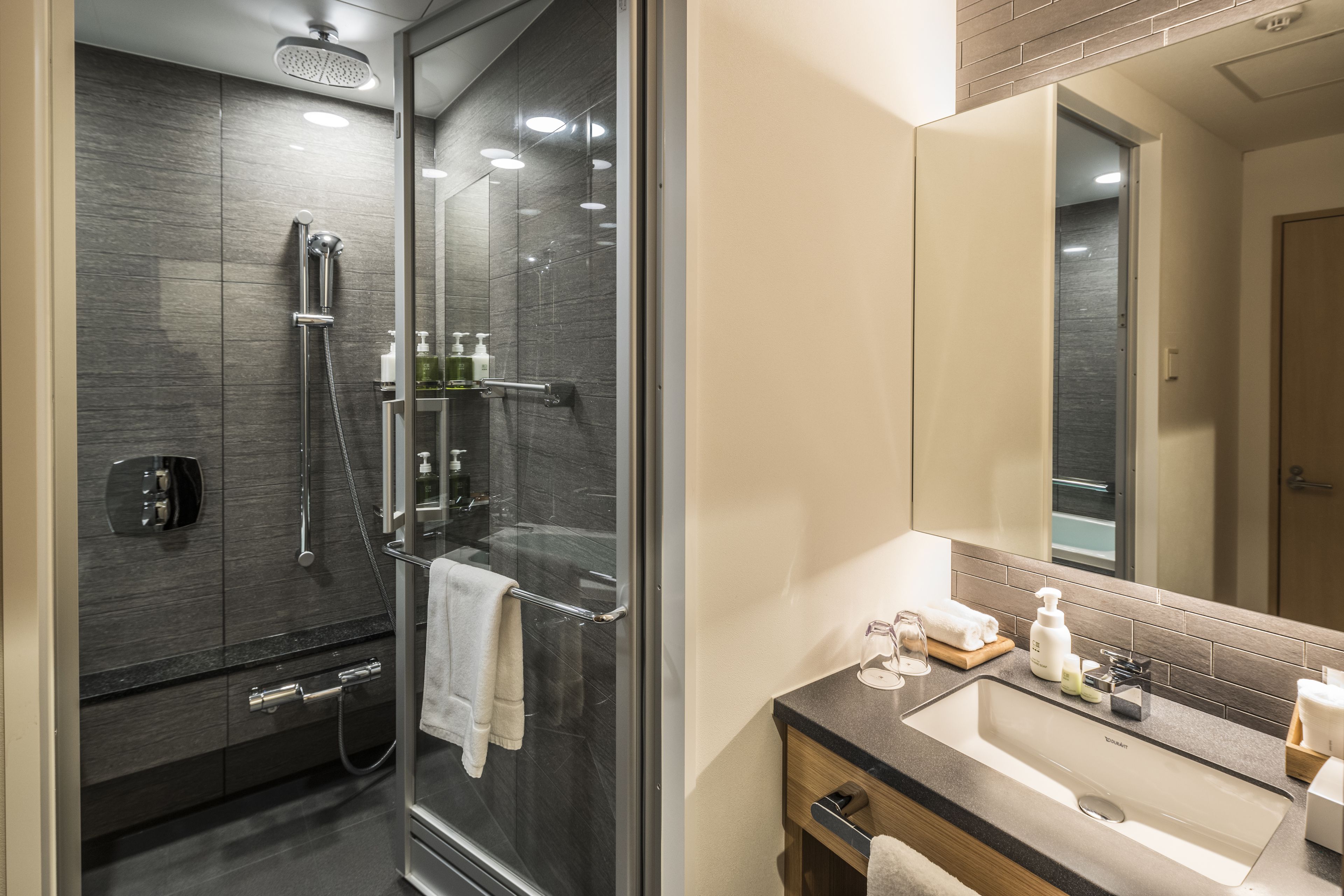 deluxe double room with living area | bathroom | combined shower/bathtub, deep-soaking bathtub, rainfall showerhead