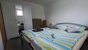 A bedroom with a bed, a wardrobe, a mirror, and a bedside table with a lamp. - Sylvana vacation apartment (Klein Vielen)