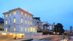 Un hotel de varios pisos con ventanas iluminadas y un letrero que dice "Albergo Rio Garni".