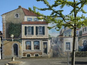 Un edificio con un letrero que dice "TRATUER" y un mural de una escena callejera.