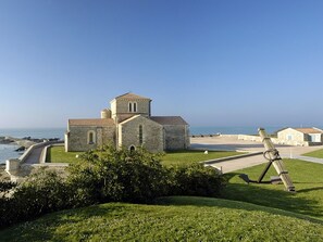 A stone church with a bell tower, located near a coastal area with a clear sky. - Charming Fisherman's House in La Chaume with 2 Bedrooms and Pet-Friendly (Les Sables-d'Olonne)