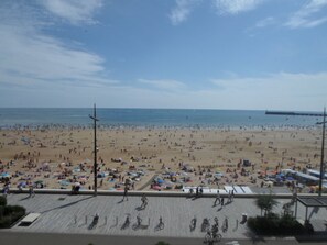 A beach with numerous umbrellas and people.