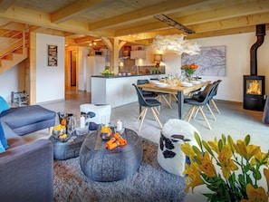 Un intérieur moderne comprenant un coin repas, une cuisine et un escalier.