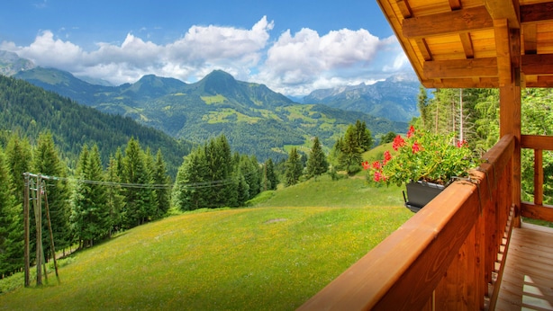 Ein hölzerner Balkon mit Blick auf eine gebirgige Landschaft.