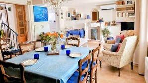 A dining area with a chandelier, a blue tablecloth, and a vase of flowers. - T3 Apartment with garden in Banyuls, parking included (Banyuls-sur-Mer)