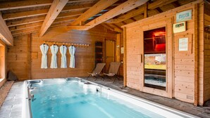 Un spa de madera con hidromasaje, toallas y sauna.