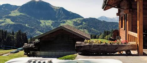 Eine Holzhütte mit Whirlpool und Bergblick.